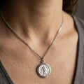Silver necklace with a pendant on a person's neck