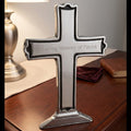Silver cross with 'In Loving Memory of Patrick' inscription on a wooden surface.