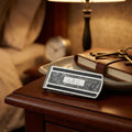 Personalized keychain on a nightstand with a lamp and books in the background
