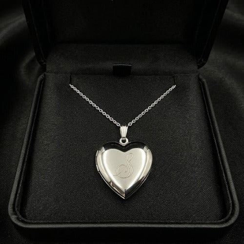 Silver heart-shaped locket on a chain in a black jewelry box