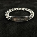Silver chain bracelet with a nameplate on a black background