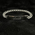 Silver bracelet with engraved name on a dark textured background