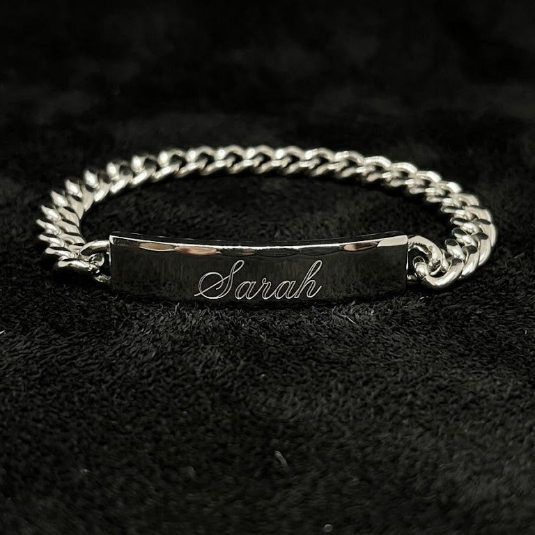 Silver bracelet with engraved name on a dark textured background