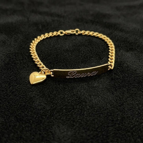 Gold bracelet with a heart charm and engraved name on a black background