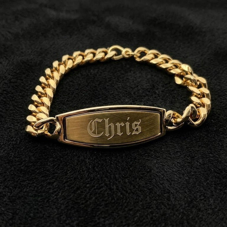 Gold chain bracelet with a nameplate on a black background