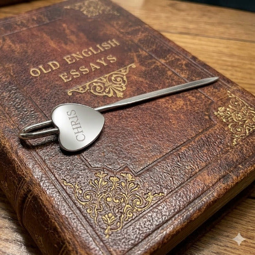 Vintage book titled 'Old English Essays' with a heart-shaped keychain on a wooden surface