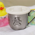 Metal cup with teddy bear design and white lid on a white surface
