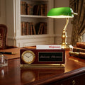 Decorative desk setup with a clock, lamp, and books in an office setting.
